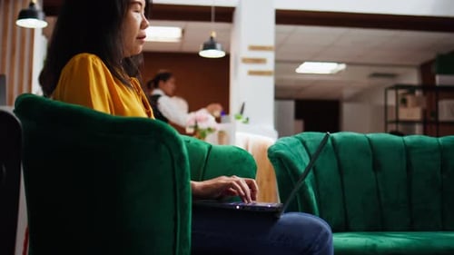 Hotel Client Solving Issues on Laptop in Lounge Area