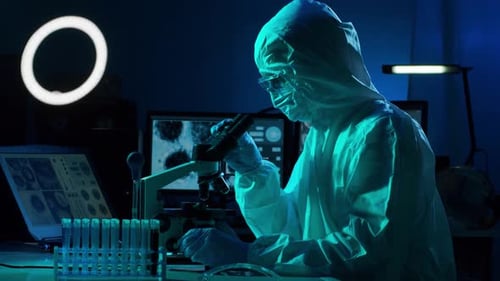 Scientist Using Microscope in a Dark Lab