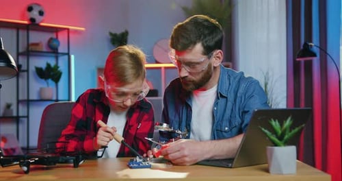 Boy and Man Working on Electronics Project Together