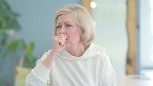 Portrait of Sick Senior Old Woman Coughing at Home