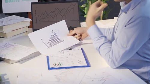 Man comparing and analyzing digital and drawn graphics.