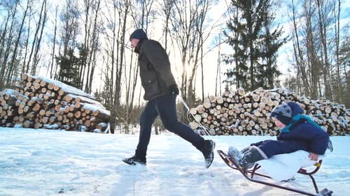 A Happy Family Sledding in the Woods