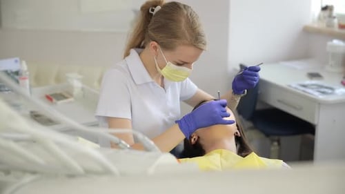 A Female Dentist Checks the Teeth of a Patient in the Office of a Dental Clinic