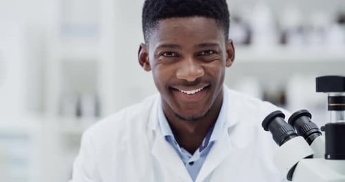 Science, research and face of black man with microscope, smile and medical engineering
