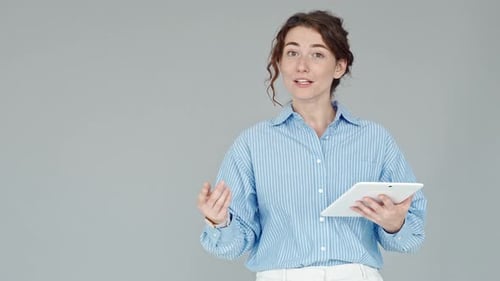Managerin einer jungen Geschäftsfrau hält Präsentation stehend an der grauen Wand