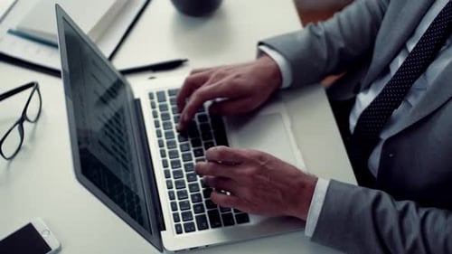 A Midsection of Businessman with Laptop Sitting at the Table, Working