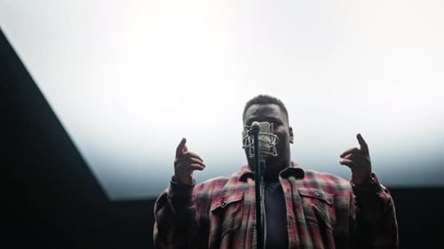 Man Singing Into a Microphone in Recording Studio