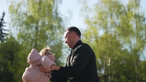 Fröhlicher lächelnder Vater spielt mit kleiner Tochter