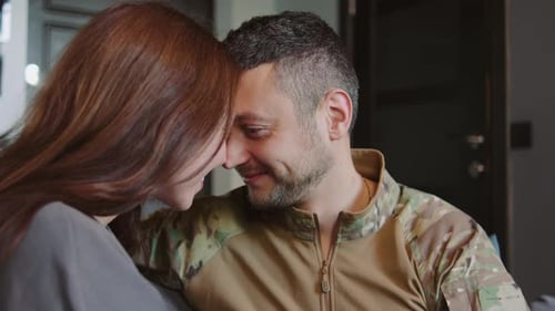 Affectionate couple at home, soldier and partner embrace
