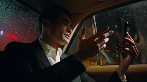 Man Video Calling in Car During Rainstorm at Night