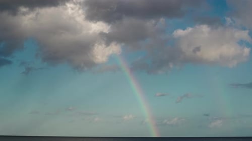 Beautiful Rainbow on the Ocean with Clouds