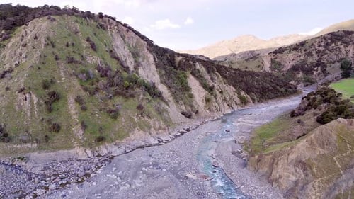 Aerial View of Serene Mountain River Flowing Through Rugged Landscape
