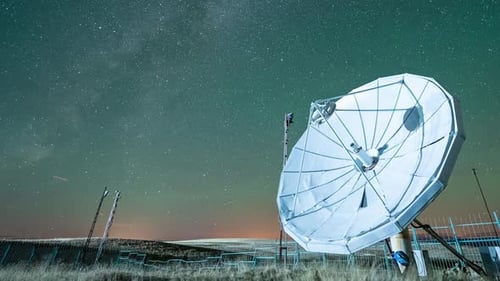 Satellitenschüssel unter Sternenhimmel mit Milchstraße