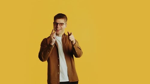 Young Adult Points and Smiles on Yellow Background