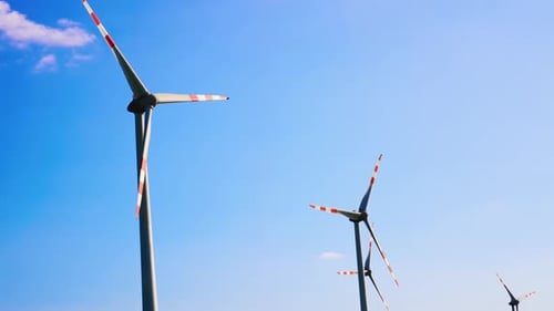 Rotating Wind Turbines Against a Clear Blue Sky
