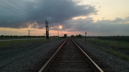 Drone Shot Tracking Backwards Over Empty Railroad Tracks At Sunset In Texas, U.S.A.