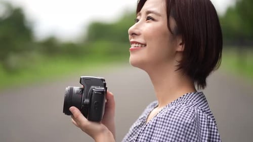 Cheerful Woman Taking Pictures on a Rural Road