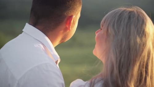 Happy Couple Having Fun Against the Background of the Sunset in the Field