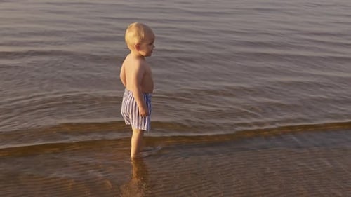 Young Child Playing in the Ocean Water on Beach