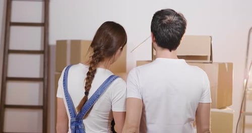 Couple Embracing in New Home with Cardboard Boxes