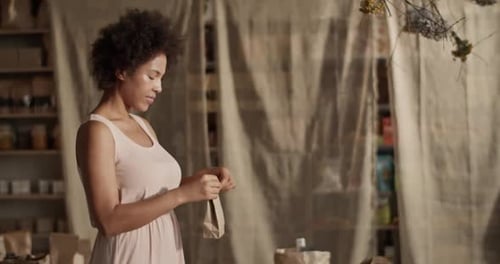 Contenido: Mujer empacando un producto ecológico por pedido
