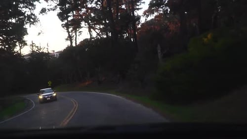 Car driving on a wooded route. Car driving on a sunset. Road Trip in slow motion.