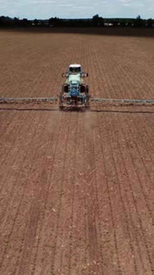 Tractor vehicles working at field. Aerial shots of the tractor while working in the field