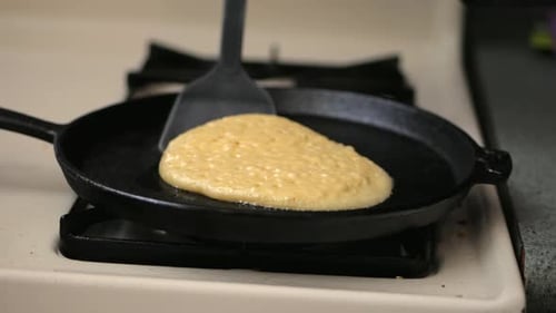 En retournant une crêpe, en gros plan.