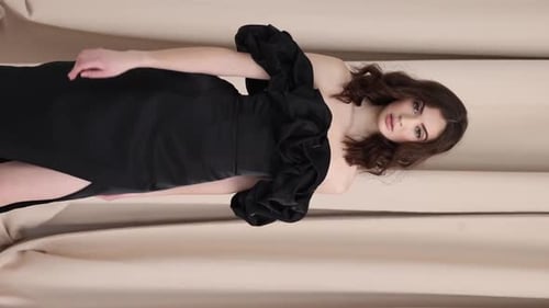 A Woman Model in a Black Dress Walks in the Studio