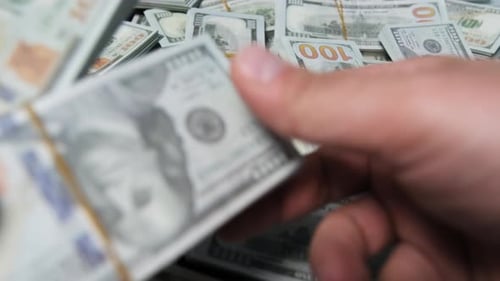 Stacks of One Hundred Dollar Bills Being Moved