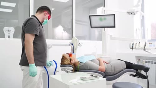 Professional UV Whitening Teeth Procedure in the Modern Dental Clinic Male Dentist Checking Female
