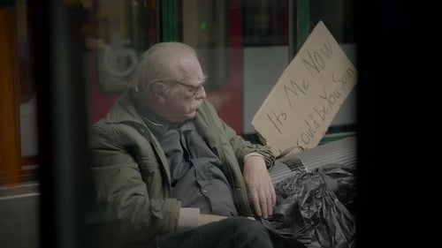 Pensive Adult Man Sits Near Cardboard Sign