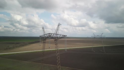 Aerial View of Power Lines Over Green Agricultural Field