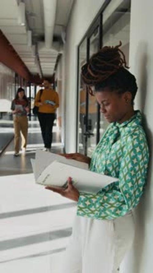 Woman Reading in a Modern Office Hallway