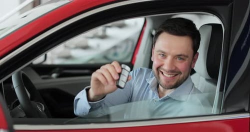 Smiling Man Holding Car Keys Inside New Car