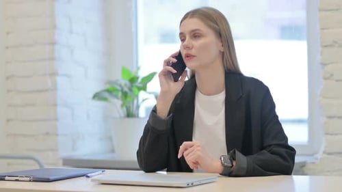 Businesswoman Talking on Phone in Modern Office