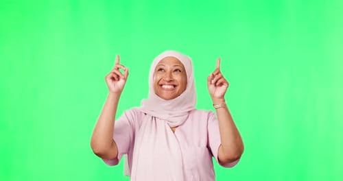 Marketing, pointing and muslim woman in a studio with green screen for advertising or promotion