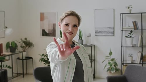 Blonde Woman Communicates with Hand Gestures in Apartment