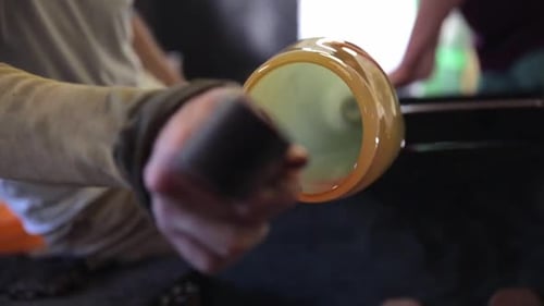 Glass Blower Shaping Molten Glass Inside Workshop