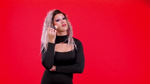 Young Adult Applying Makeup Against a Red Background