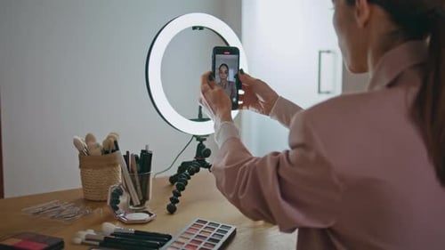 Concepto de aprendizaje en línea de Closeup Influencer ajustando el trípode del teléfono inteligente en casa