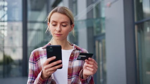 Pretty Young Positive Woman Using Mobile Cell Phone Holding Credit Bank Card