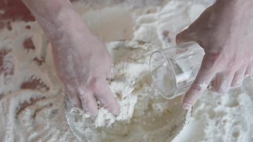 Hands Mixing Dough with Flour and Water