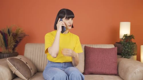 Young Woman Talking on Mobile Phone at Home