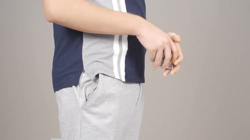 Man Putting Money Into Gray Sweatpants Pocket