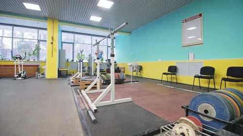 Barbell on Rack and Boxes with Weights in Bodybuilding Gym