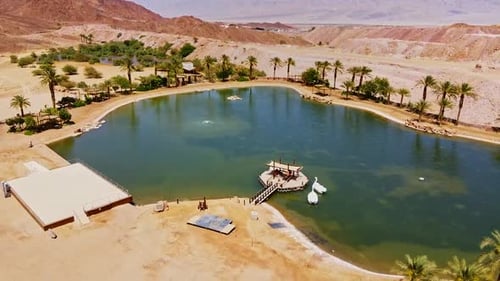 Aerial view of a stunning desert oasis, with turquoise waters contrasting golden sand dunes in Israe