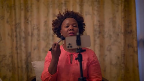 Woman Applies Makeup in front of Smartphone