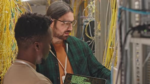 Funcionários do data center codificando em laptop na sala de servidores