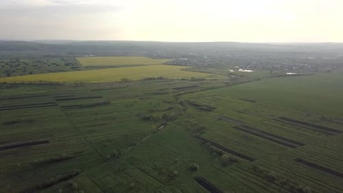 Aerial View of Green Hills with Forest and Dark Rain Clouds in Summer
